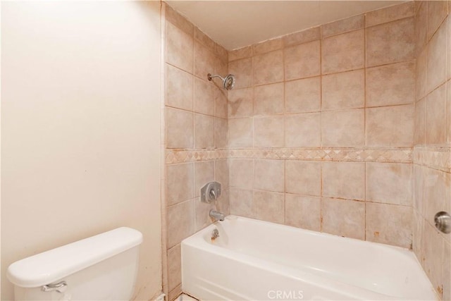 bathroom featuring tiled shower / bath and toilet