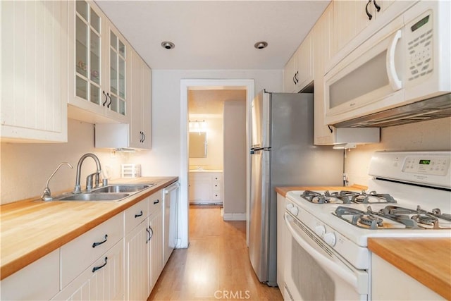 kitchen with white appliances, light hardwood / wood-style floors, sink, and white cabinets