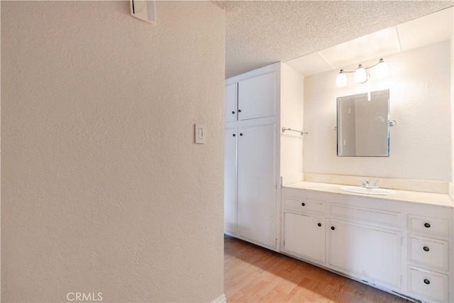 bathroom with vanity, hardwood / wood-style floors, and a textured ceiling