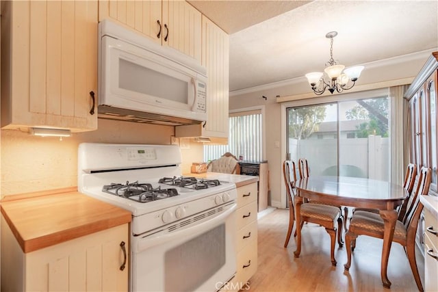 kitchen with crown molding, white appliances, hanging light fixtures, a chandelier, and light wood-type flooring