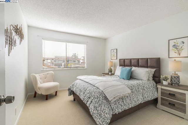 bedroom featuring a textured ceiling and light carpet