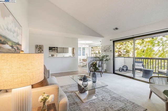 living room with high vaulted ceiling, light colored carpet, an inviting chandelier, and a textured ceiling