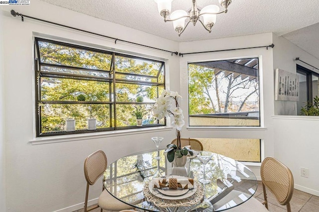 tiled dining room with a wealth of natural light, a textured ceiling, and an inviting chandelier