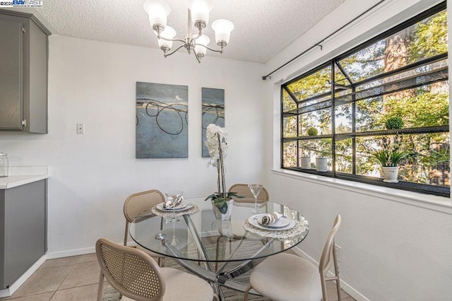 dining area featuring a textured ceiling, light tile patterned floors, and a notable chandelier