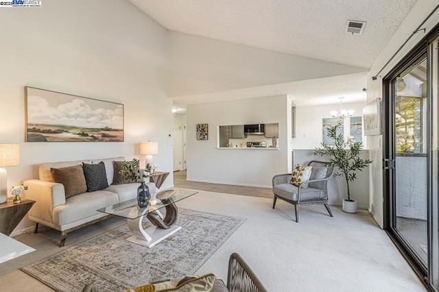 carpeted living room with a textured ceiling, an inviting chandelier, and vaulted ceiling