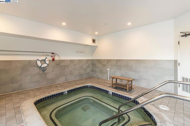 view of swimming pool with an indoor hot tub