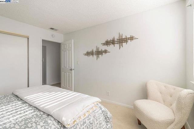 bedroom featuring a textured ceiling, carpet floors, and a closet