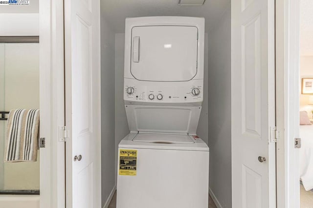 clothes washing area with stacked washer and dryer