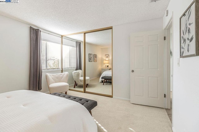 carpeted bedroom featuring a closet and a textured ceiling