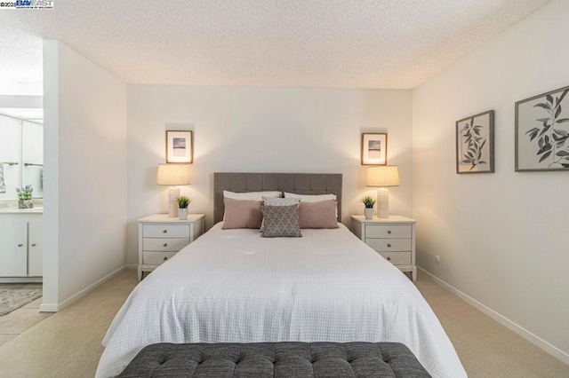 bedroom featuring light carpet and a textured ceiling