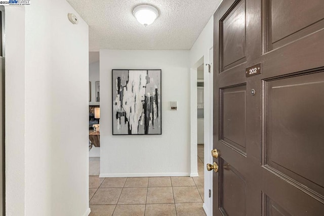 interior space with a textured ceiling and light tile patterned floors