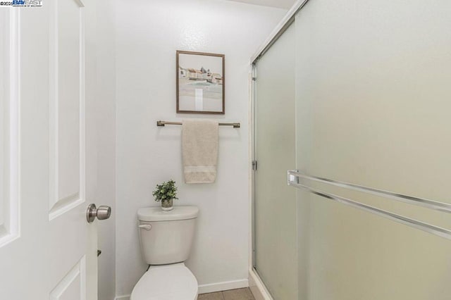 bathroom with toilet, an enclosed shower, and tile patterned floors