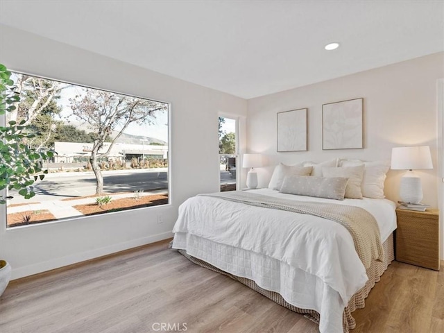 bedroom with recessed lighting, baseboards, and wood finished floors