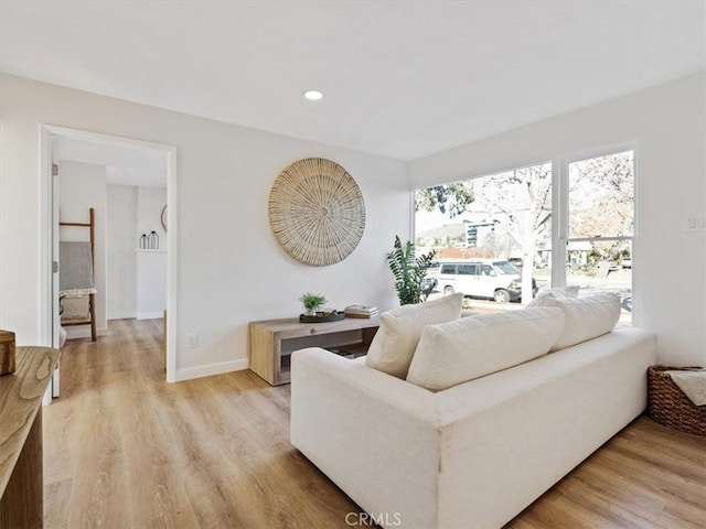 living room with light wood finished floors, baseboards, and recessed lighting