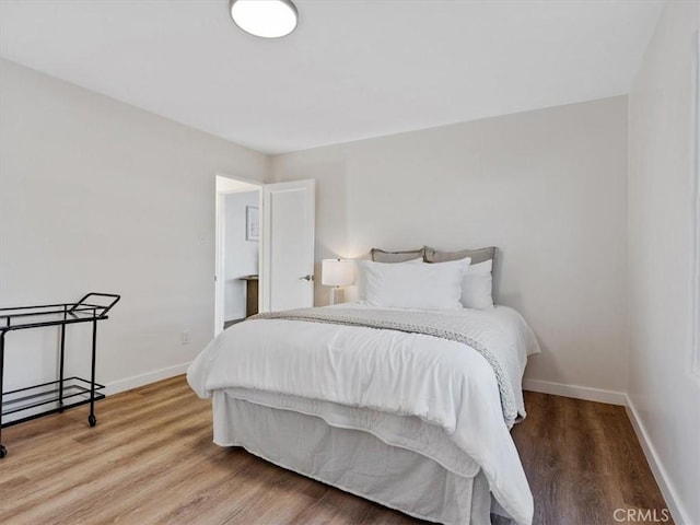 bedroom featuring baseboards and wood finished floors