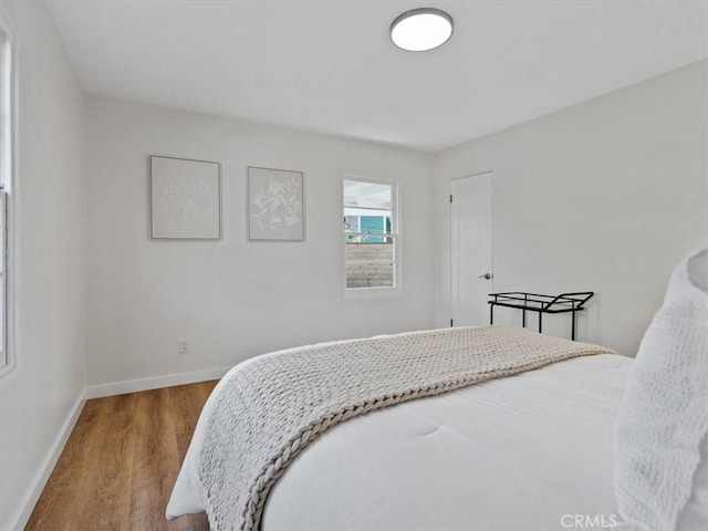 bedroom featuring baseboards and wood finished floors