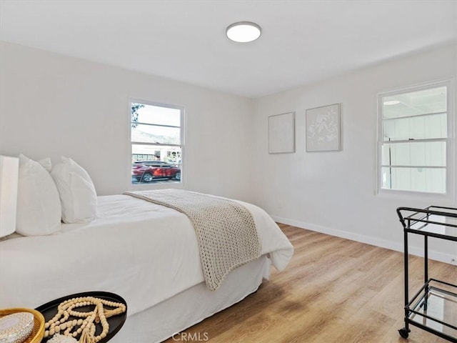 bedroom featuring baseboards and light wood finished floors