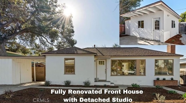 view of front of house featuring fence, a chimney, and stucco siding