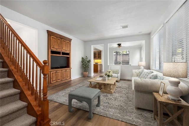 living room with dark wood-type flooring and ceiling fan