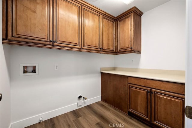 laundry room with cabinets, dark hardwood / wood-style flooring, hookup for a gas dryer, and hookup for a washing machine