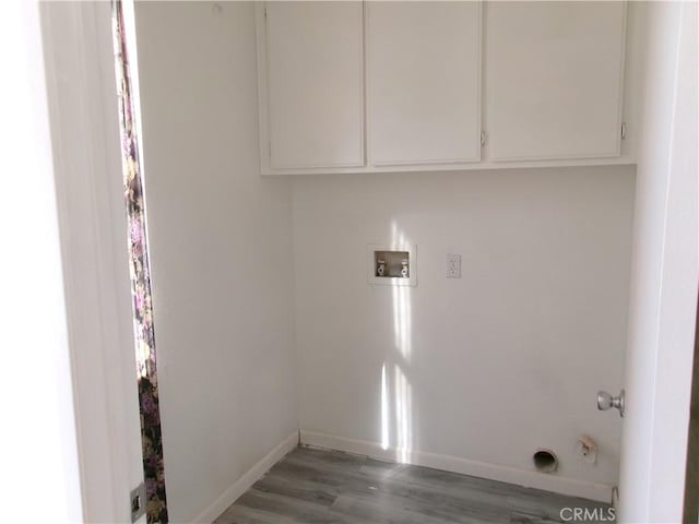 laundry room featuring hardwood / wood-style flooring, washer hookup, and cabinets