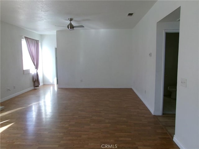 empty room featuring ceiling fan and dark hardwood / wood-style flooring