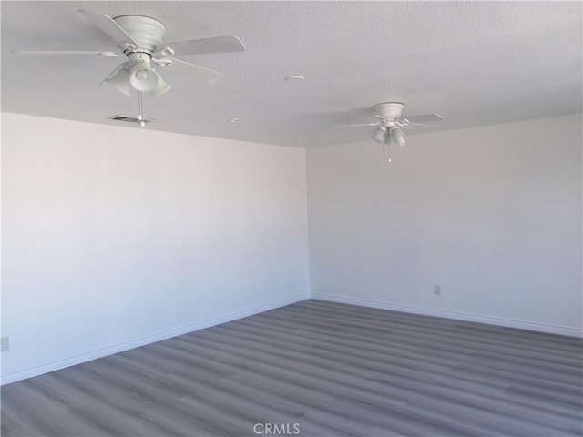 unfurnished room with ceiling fan, a textured ceiling, and dark hardwood / wood-style floors