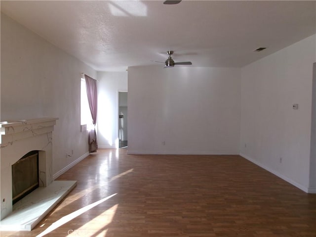 unfurnished living room featuring ceiling fan and dark hardwood / wood-style floors