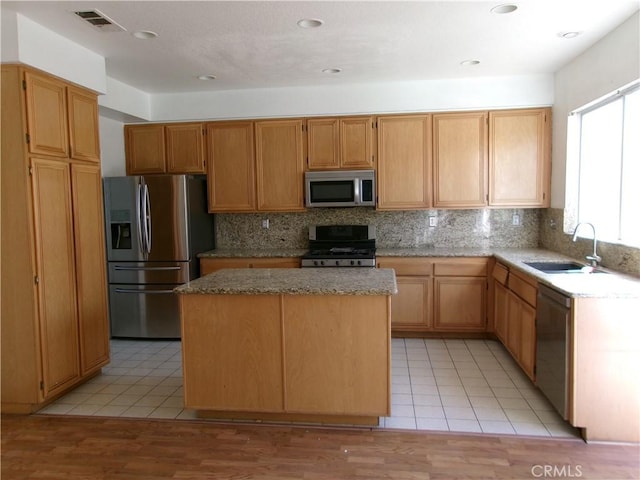 kitchen featuring sink, a center island, stainless steel appliances, and light tile patterned flooring