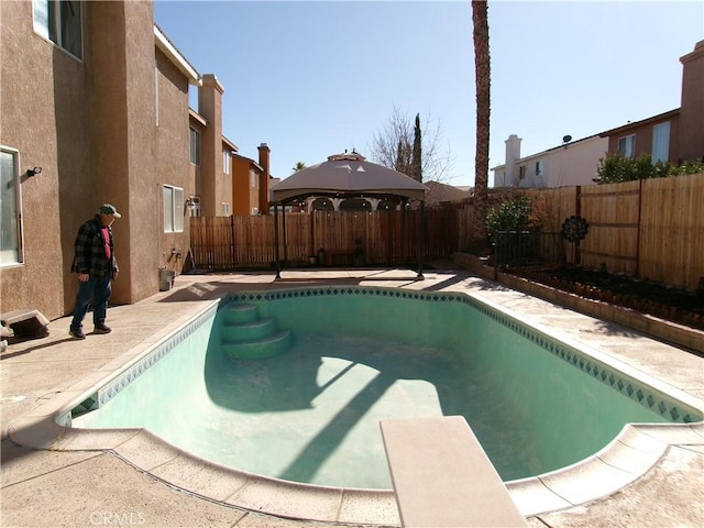 view of swimming pool featuring a gazebo, a diving board, and a patio