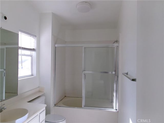 full bathroom featuring toilet, vanity, and combined bath / shower with glass door