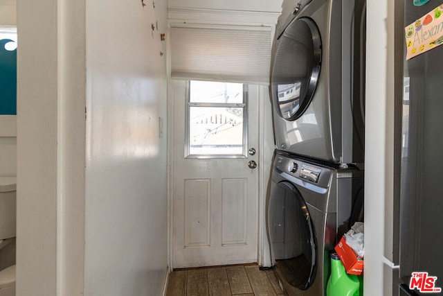 washroom featuring stacked washing maching and dryer and wood-type flooring