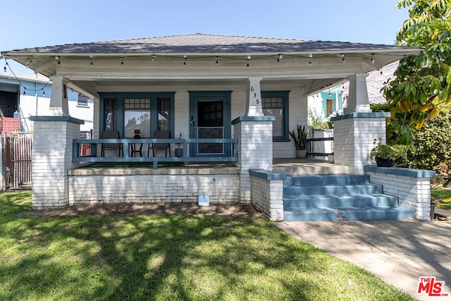 view of front of house featuring covered porch and a front lawn