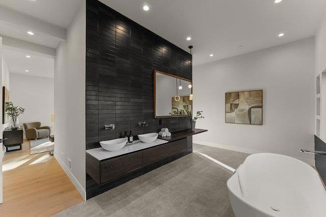 bathroom featuring hardwood / wood-style floors, a washtub, and vanity