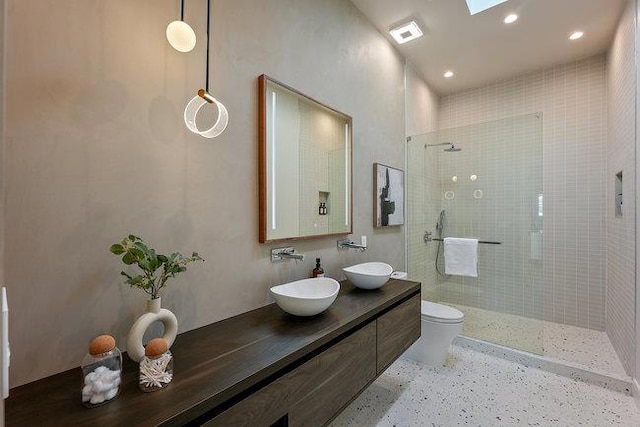 bathroom with toilet, walk in shower, a skylight, and vanity