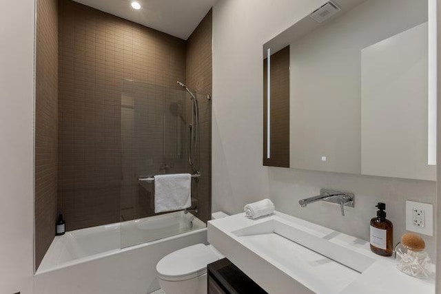 full bathroom with toilet, tiled shower / bath, and vanity