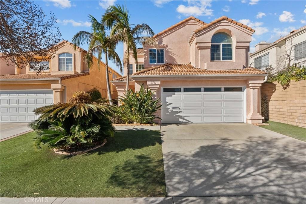 mediterranean / spanish-style house featuring a garage and a front lawn