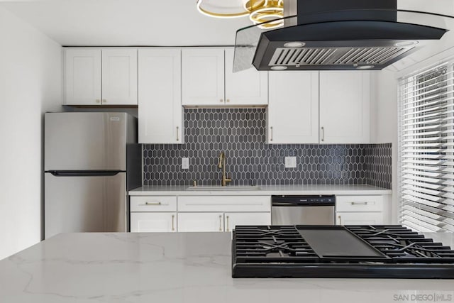 kitchen featuring light stone countertops, island range hood, sink, white cabinets, and stainless steel appliances