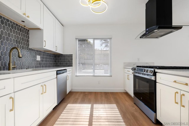 kitchen featuring tasteful backsplash, range hood, white cabinets, sink, and stainless steel appliances