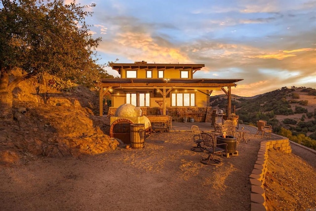 back of property at dusk with a patio area