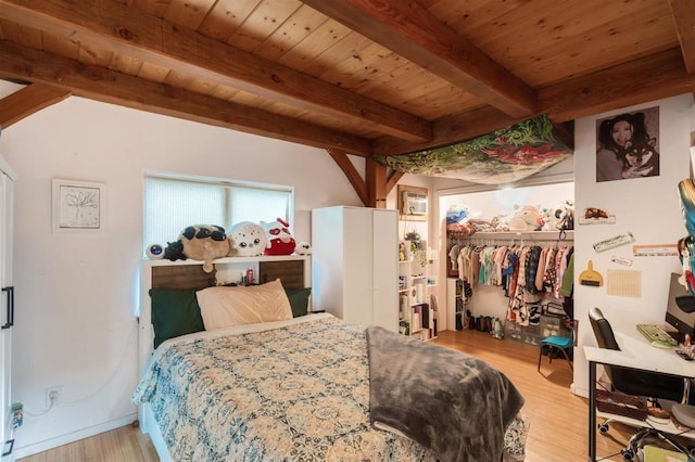 bedroom featuring a closet, beamed ceiling, wooden ceiling, and wood finished floors