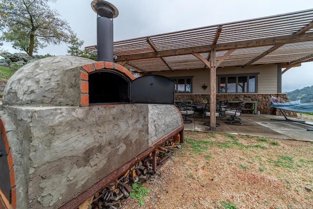 exterior space with stone siding and a patio