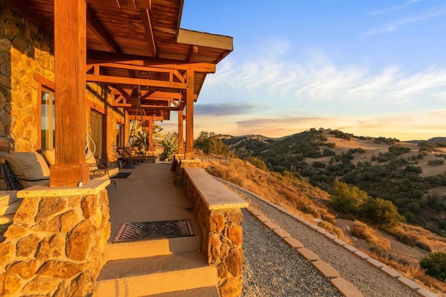 patio terrace at dusk featuring a mountain view