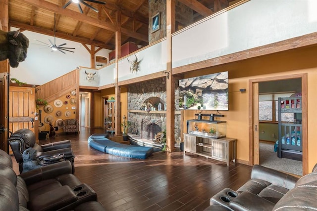 living room with wooden ceiling, a fireplace, wood finished floors, a ceiling fan, and beamed ceiling