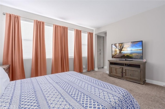 bedroom featuring light colored carpet and multiple windows