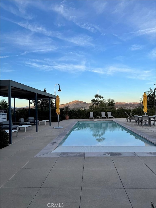 view of pool with a mountain view and a patio area