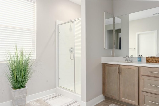 bathroom with vanity and a shower with door