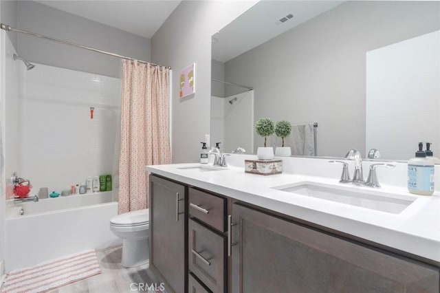 full bathroom featuring toilet, shower / tub combo with curtain, and vanity