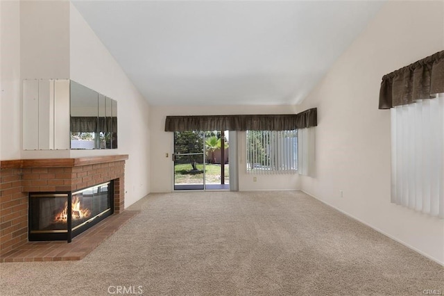 unfurnished living room with a fireplace, carpet floors, and vaulted ceiling