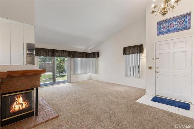 unfurnished living room featuring a chandelier, carpet, a fireplace, and high vaulted ceiling